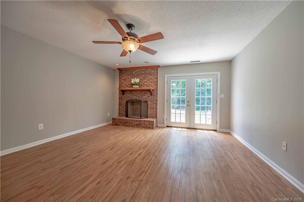 209 Eagle Road Belmont, NC 28012 - Photo 12 of 25 an empty room with wooden floor fan and windows