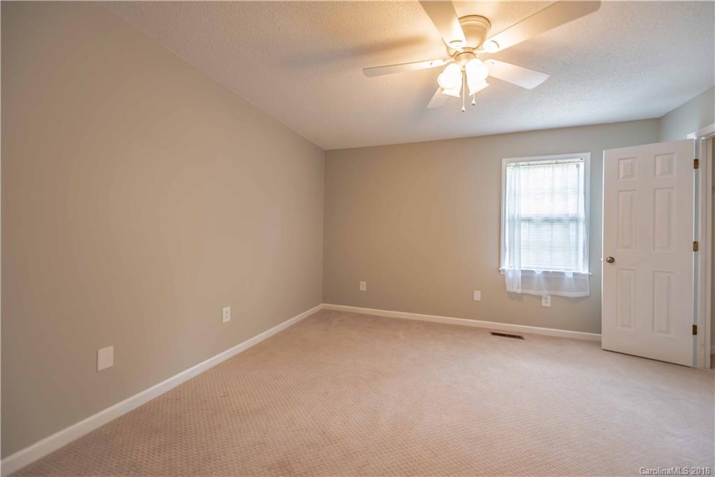 209 Eagle Road Belmont, NC 28012 - Photo 20 of 25 an empty room with a chandelier fan and windows