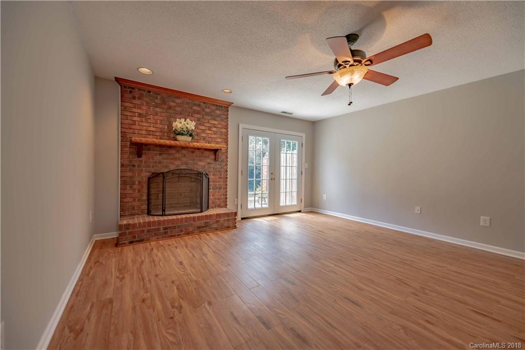 209 Eagle Road Belmont, NC 28012 - Photo 6 of 25 an empty room with wooden floor fan and windows