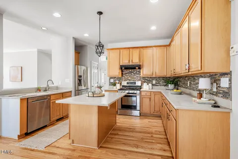 a kitchen with stainless steel appliances granite countertop a sink a stove and refrigerator