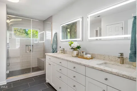 a bathroom with a granite countertop sink mirror and shower