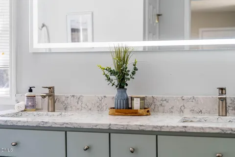 a bathroom with a granite counter sink and a white cabinets