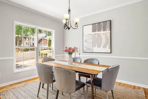 a dining room with furniture a chandelier and wooden floor
