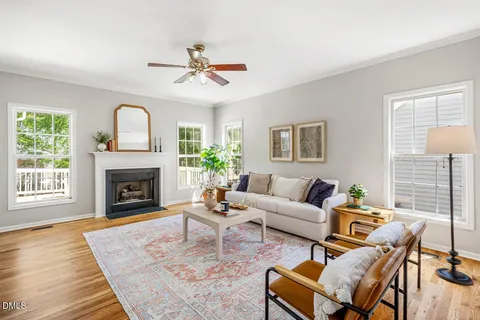 a living room with furniture a fireplace and wooden floor