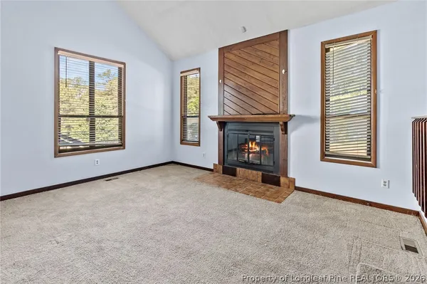 a view of an empty room with a fireplace and a window