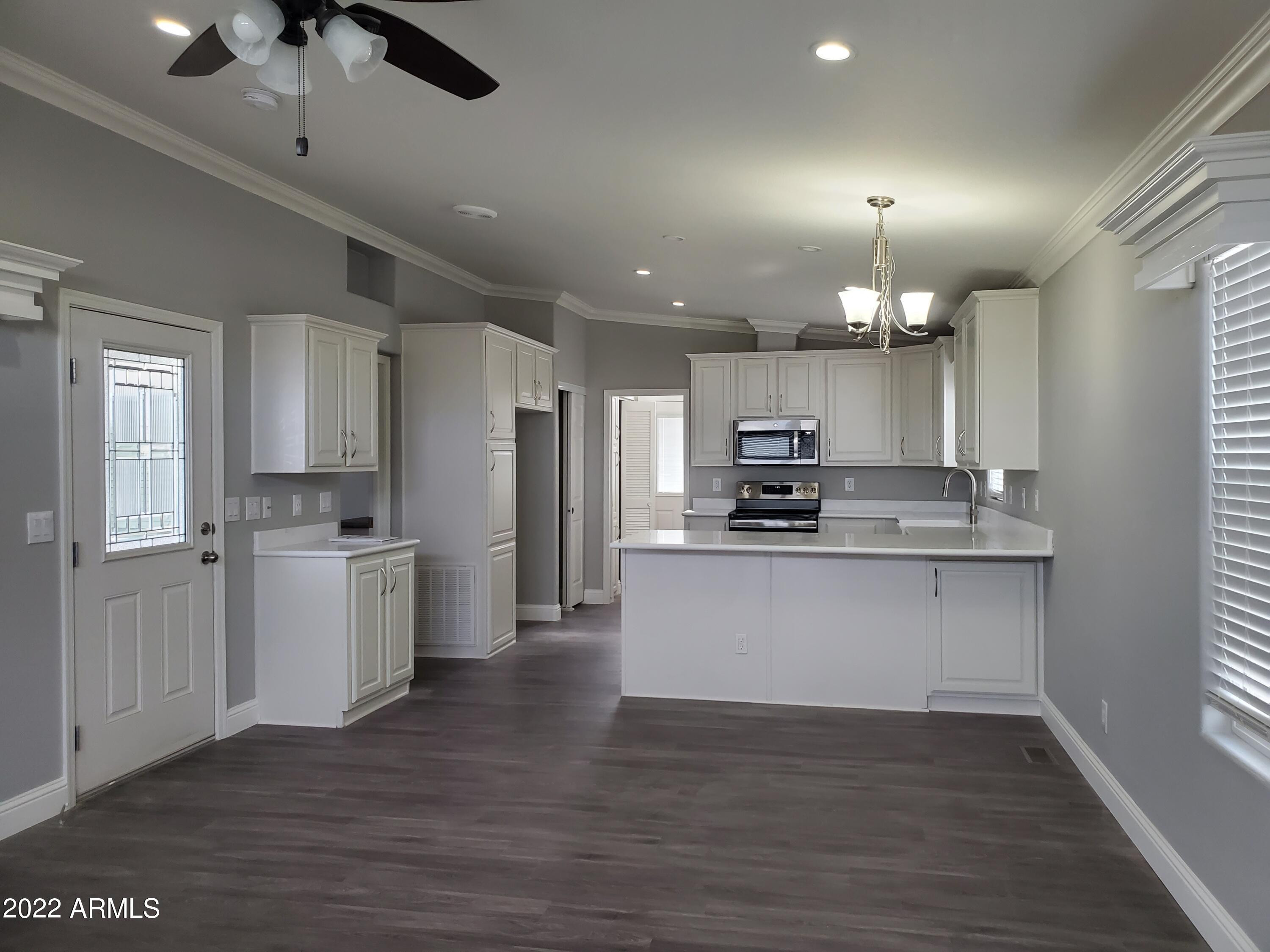 7750 East Broadway Road, Unit LOT 857 Mesa, AZ 85208 - Photo 1 of 17 a view of kitchen with granite countertop stainless steel appliances cabinets a sink and a counter top space