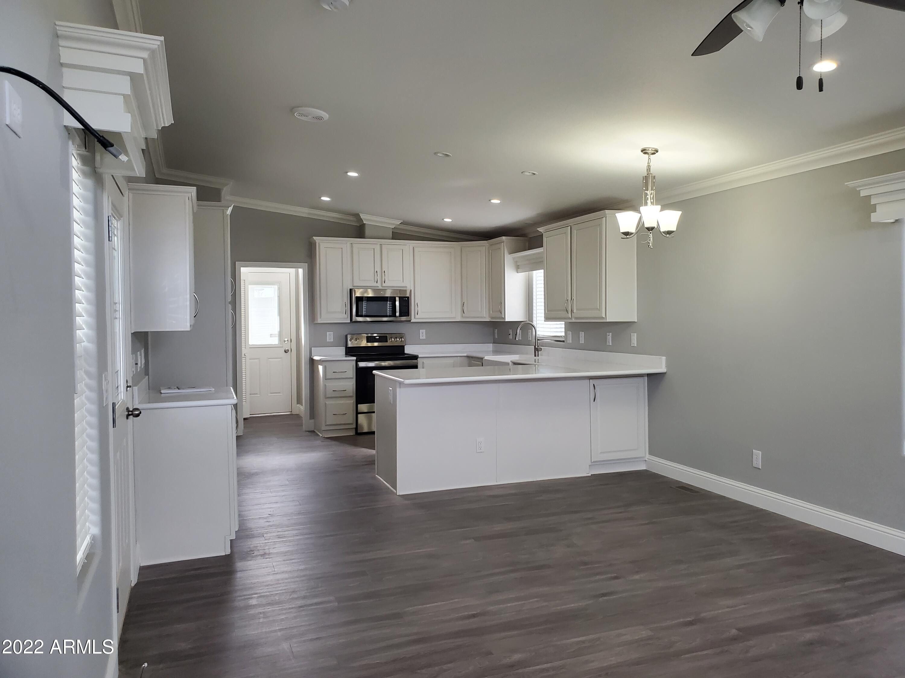 7750 East Broadway Road, Unit LOT 857 Mesa, AZ 85208 - Photo 5 of 17 a kitchen with a refrigerator and a sink