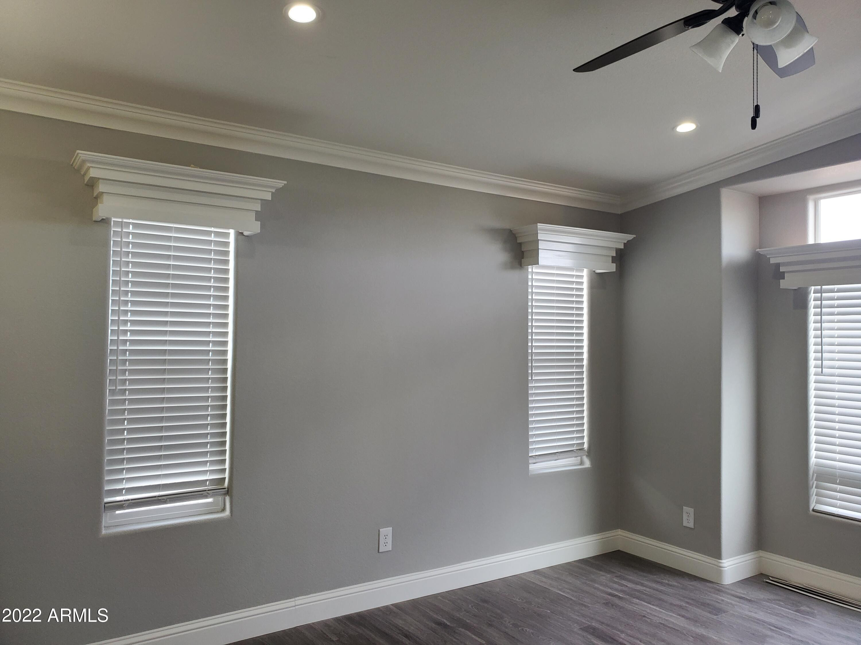 7750 East Broadway Road, Unit LOT 857 Mesa, AZ 85208 - Photo 7 of 17 a view of an empty room with wooden floor and a window