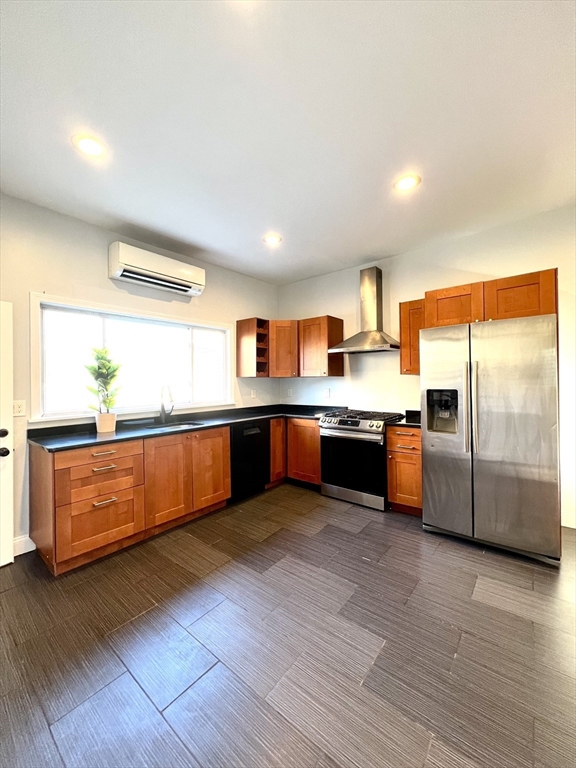 113 Moore Street, Unit 2 Boston, MA 02128 - Photo 3 of 19 a large kitchen with stainless steel appliances wooden floors and white walls