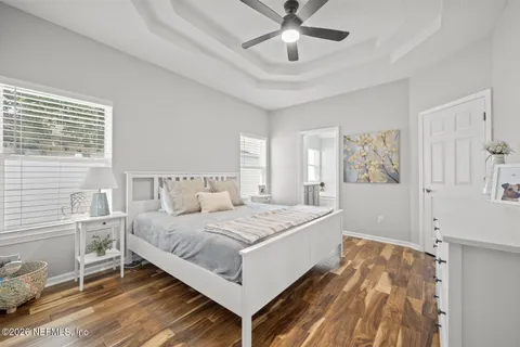 a bedroom with a bed and a flat tv screen on dresser