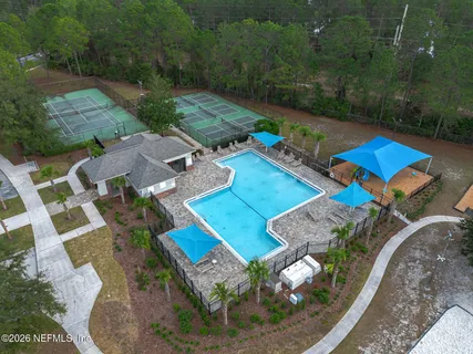 a front view of a house with a yard and fountain in middle of the road