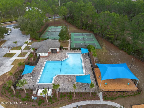 a front view of a house with a yard and fountain in middle of the road