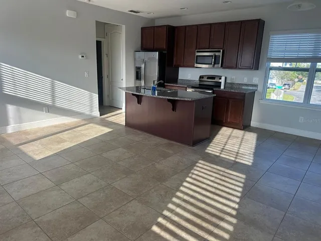 a kitchen with stainless steel appliances granite countertop a stove a sink and a microwave