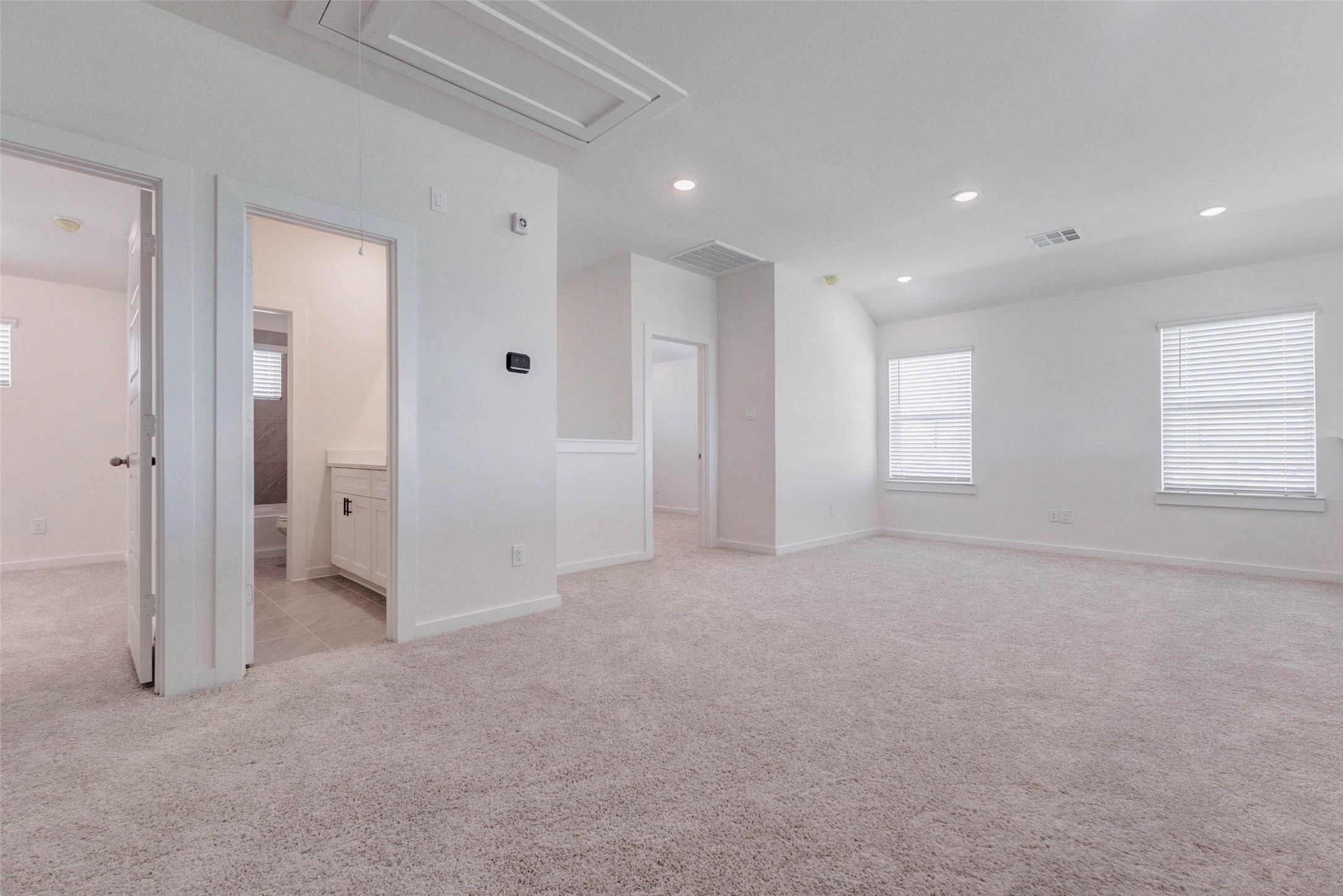 1206 Hemet Court Rosharon, TX 77583 - Photo 15 of 21 Spacious upstairs game room or flex area with soft carpet, recessed lighting, multiple windows, and an open connection to nearby bedrooms and bath spaces. This large bonus room is ideal for movie nights, play space, gaming, studying, hobbies, or a casual lounge, offering valuable flexibility for today’s lifestyle.