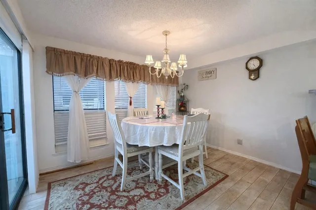 a dining room with furniture a chandelier and wooden floor