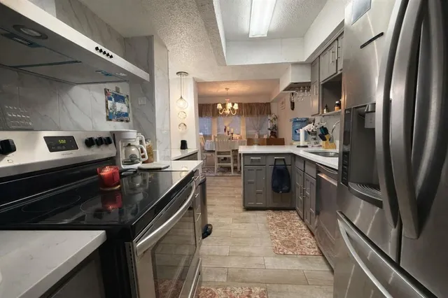 a kitchen with stainless steel appliances granite countertop a sink stove and refrigerator