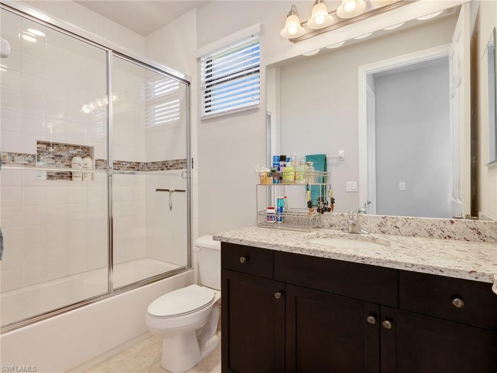 2756 Crystal Way Naples, FL 34119 - Photo 28 of 50 a bathroom with a sink vanity granite toilet and a shower