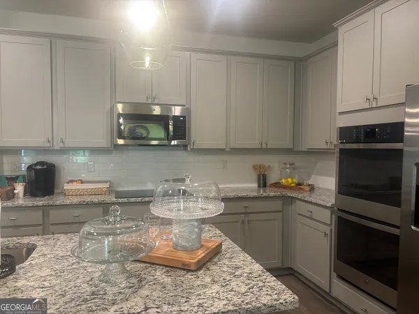 a kitchen with a stove a sink and cabinets