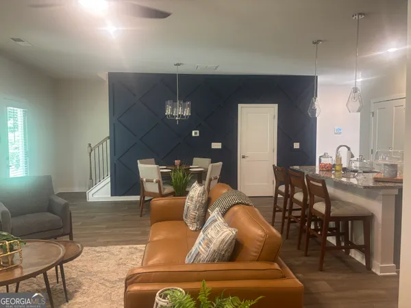 a living room with furniture a chandelier and a dining table