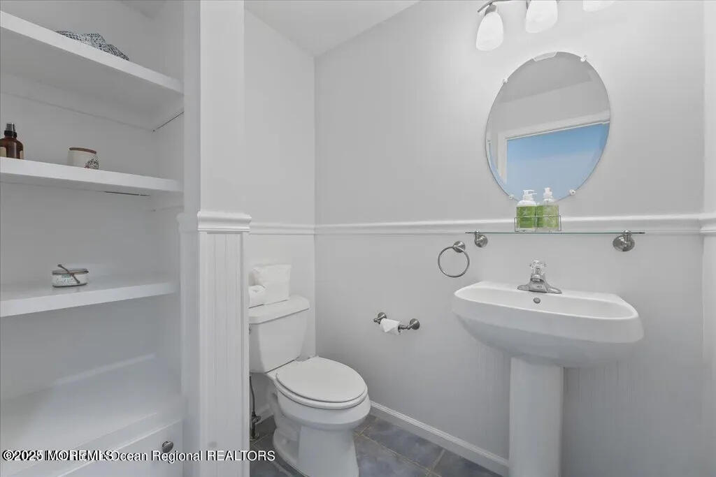 303 Highway 35, Unit 1 Point Pleasant Beach, NJ 08742 - Photo 14 of 25 a bathroom with a sink a toilet and mirror