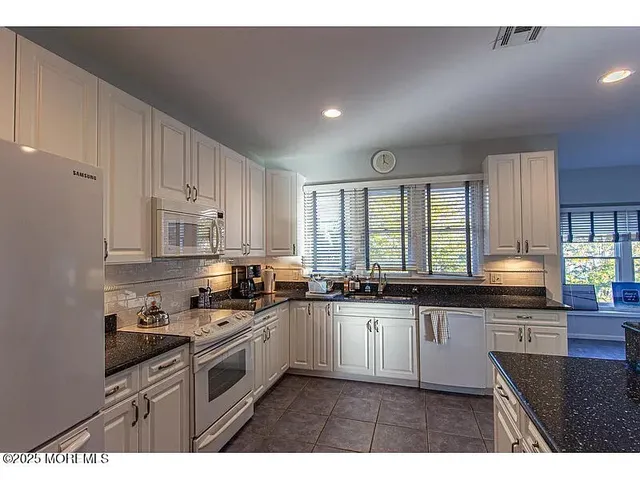 a kitchen with stainless steel appliances granite countertop a stove top oven a sink dishwasher and cabinets