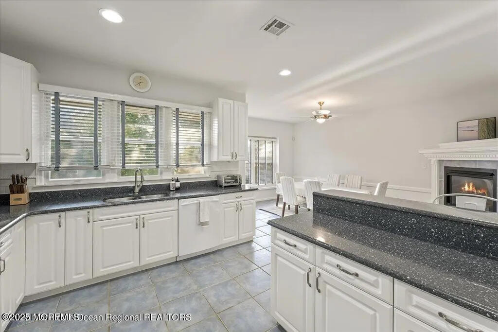 303 Highway 35, Unit 1 Point Pleasant Beach, NJ 08742 - Photo 9 of 25 a large kitchen with granite countertop a sink and white cabinets