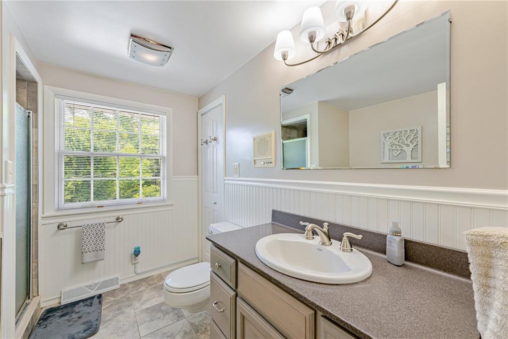905 Lombard Street Irwin, PA 15642 - Photo 20 of 30 a bathroom with a granite countertop sink a toilet and a mirror