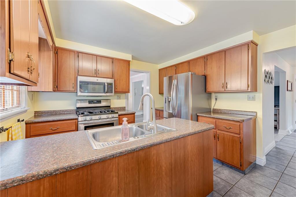 905 Lombard Street Irwin, PA 15642 - Photo 10 of 30 a kitchen with stainless steel appliances granite countertop a sink refrigerator stove and microwave