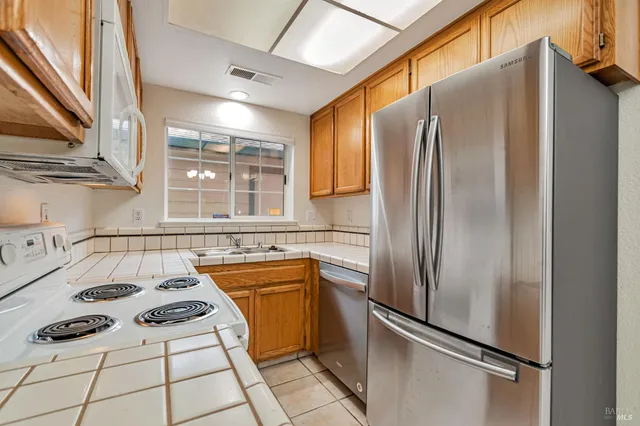 a kitchen with a refrigerator a sink and cabinets