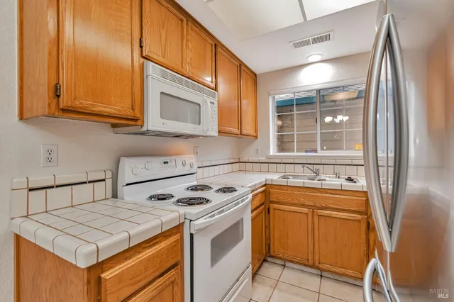a kitchen that has a sink a stove and a microwave