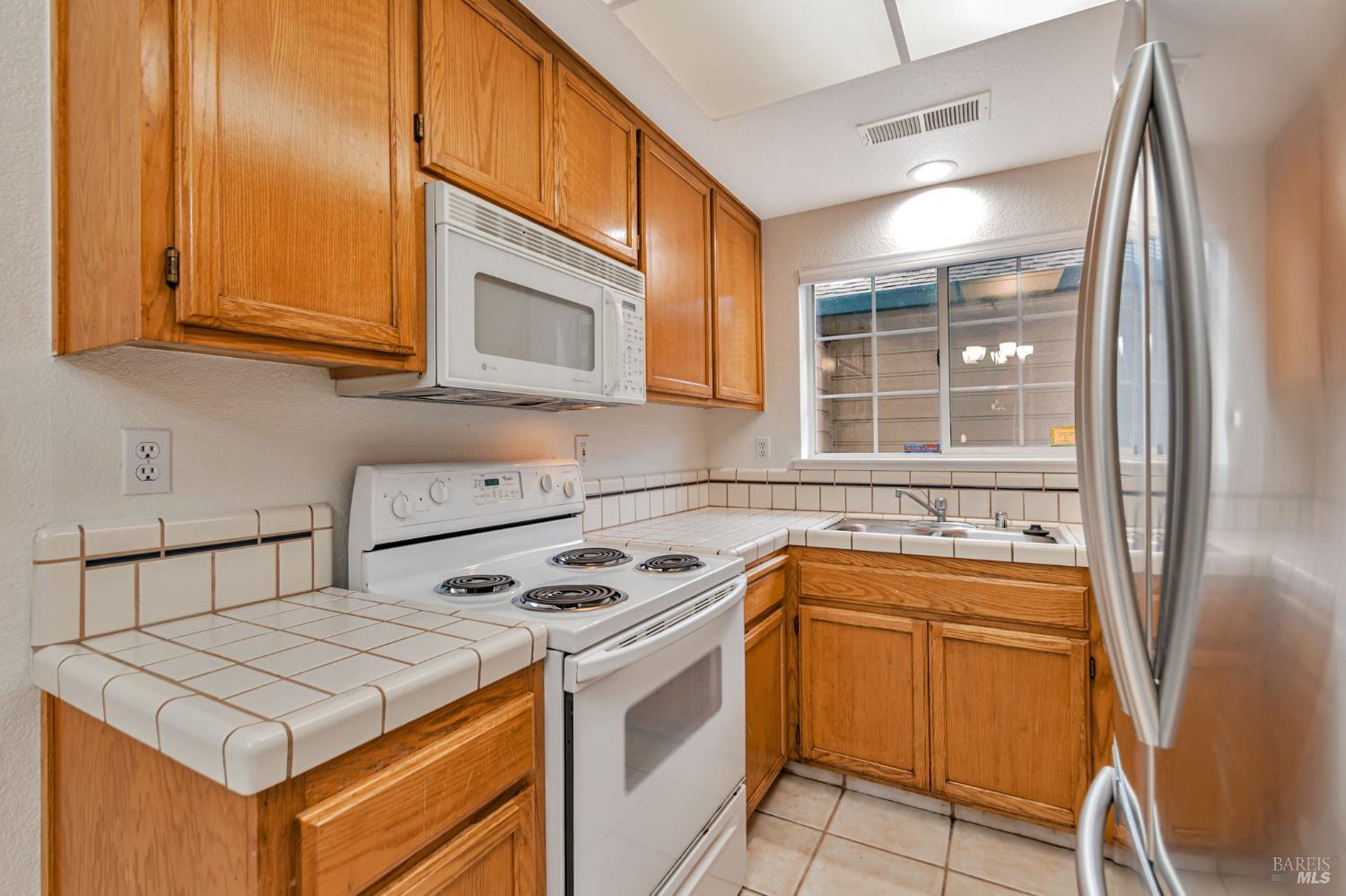 1239 Eardley Avenue Santa Rosa, CA 95401 - Photo 9 of 25 a kitchen that has a sink a stove and a microwave
