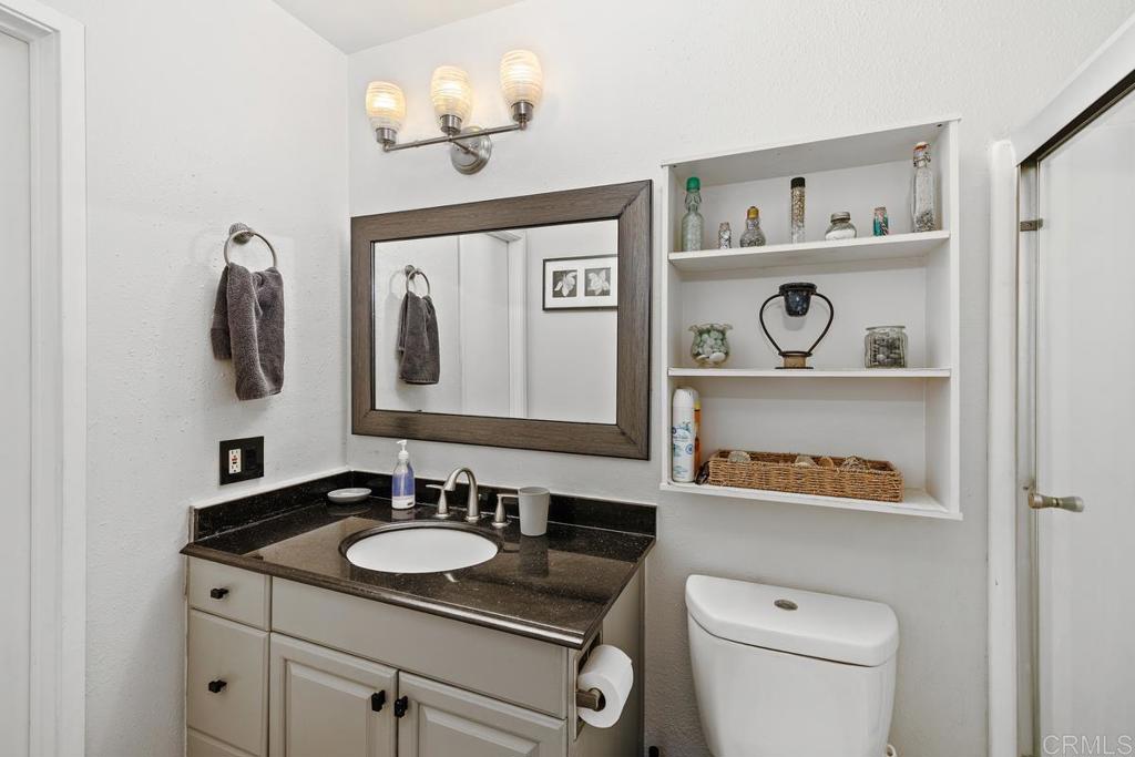 12553 Mapleview Street, Unit 28 Lakeside, CA 92040 - Photo 16 of 26 a bathroom with a toilet a sink and a mirror