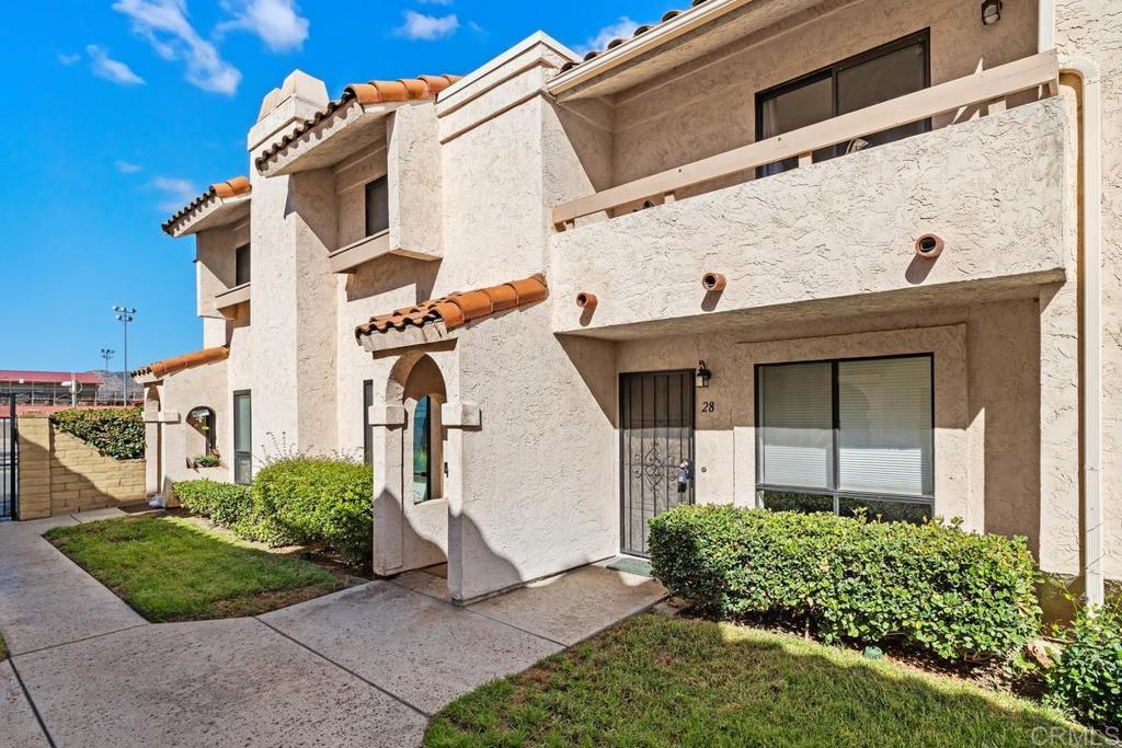 12553 Mapleview Street, Unit 28 Lakeside, CA 92040 - Photo 3 of 26 a view of a white house with large windows and a small yard