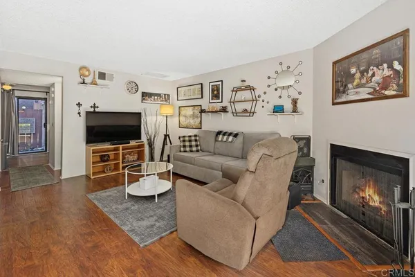 a living room with furniture a flat screen tv and a fireplace