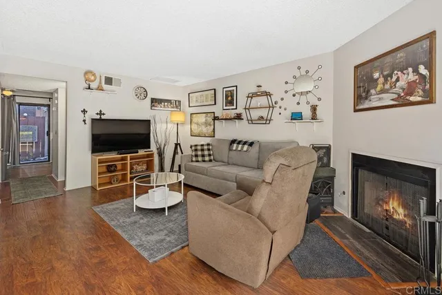 a living room with furniture a flat screen tv and a fireplace