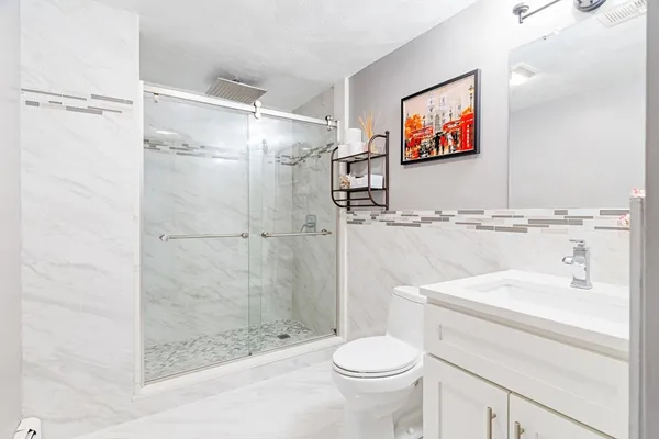 a bathroom with a sink a toilet and shower