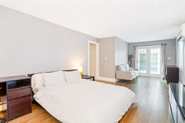 a bedroom with a bed and wooden floor