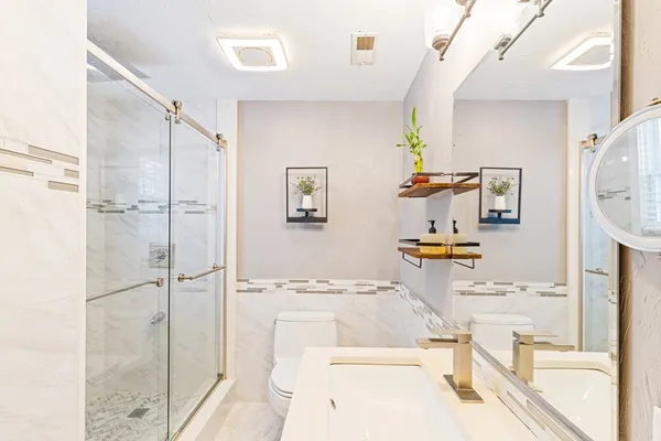 a bathroom with a sink mirror and shower