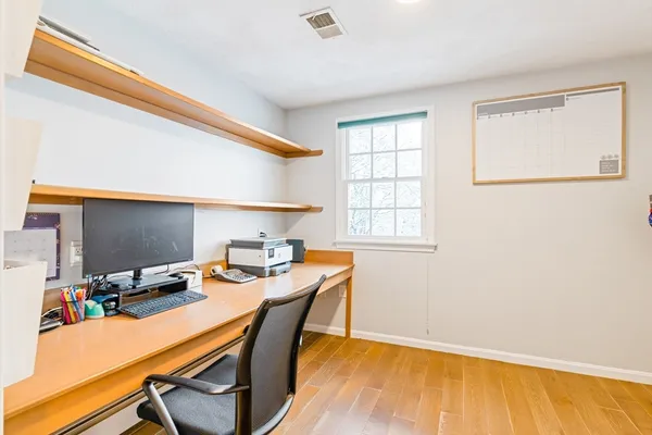 a view of a workspace with furniture and a window