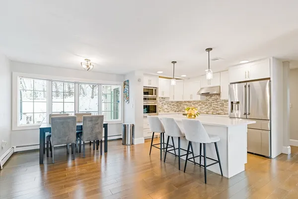 a view of a dining room with furniture wooden floor and kitchen view