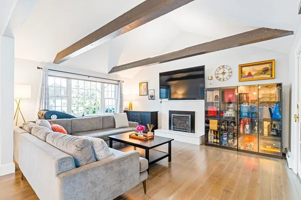 a living room with fireplace furniture and a large window