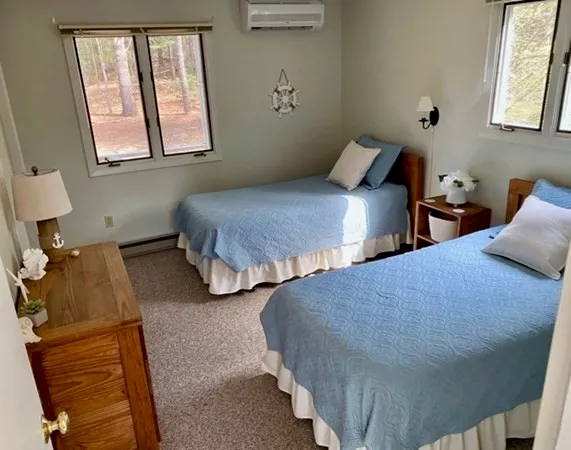a bedroom with two beds and painting on the wall
