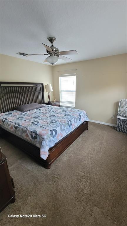 1040 Marcello Boulevard Kissimmee, FL 34746 - Photo 18 of 24 a bedroom with a bed and a chandelier