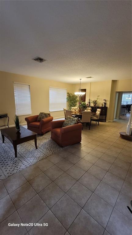 1040 Marcello Boulevard Kissimmee, FL 34746 - Photo 2 of 24 a living room with furniture and a lamp