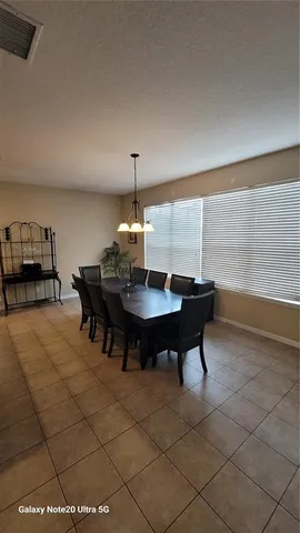 a view of a dining room with furniture and chandelier