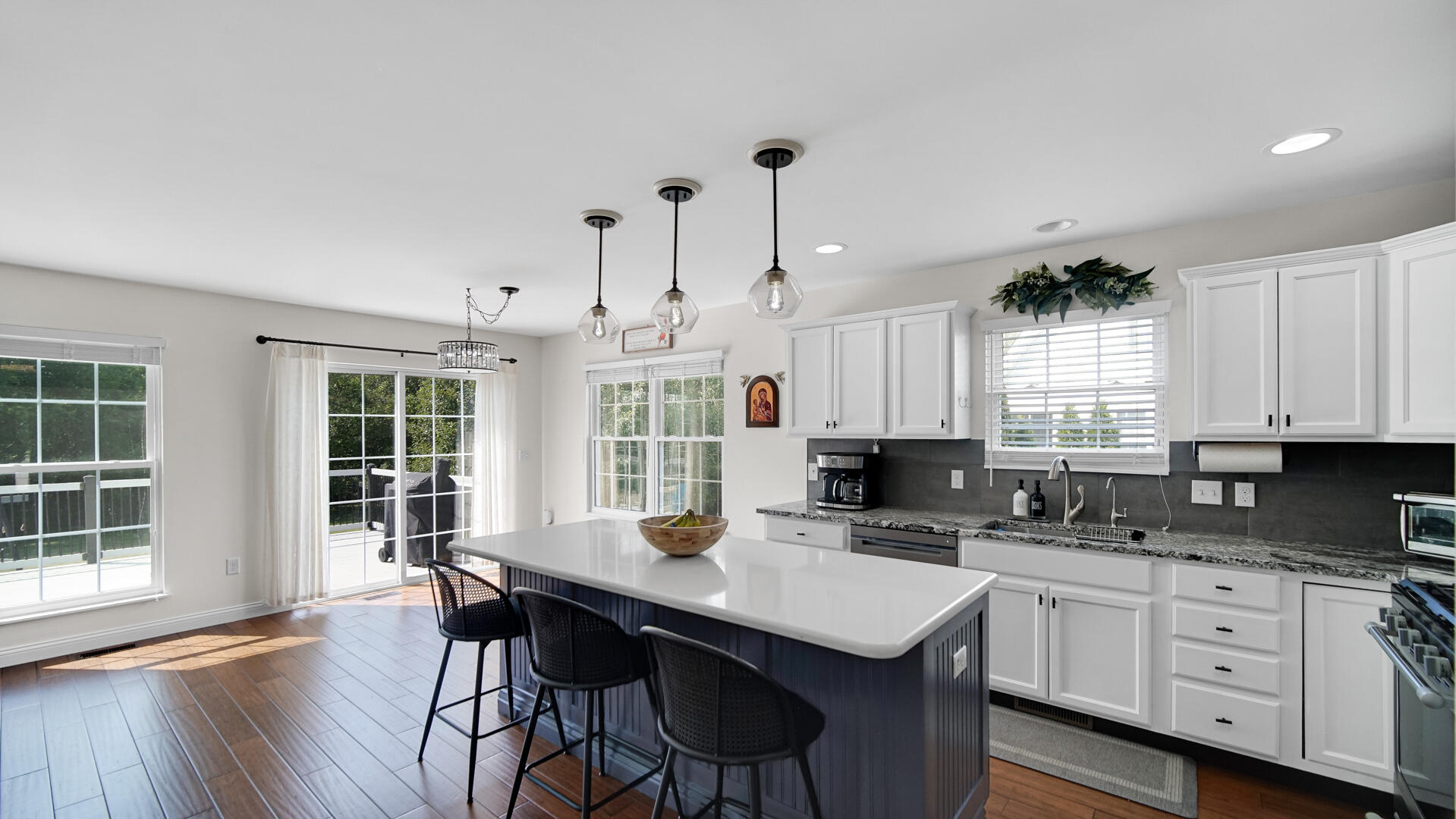 10300 Illinois Street Crown Point, IN 46307 - Photo 3 of 29 a kitchen with stainless steel appliances granite countertop a stove a sink dishwasher a dining table and chairs with wooden floor