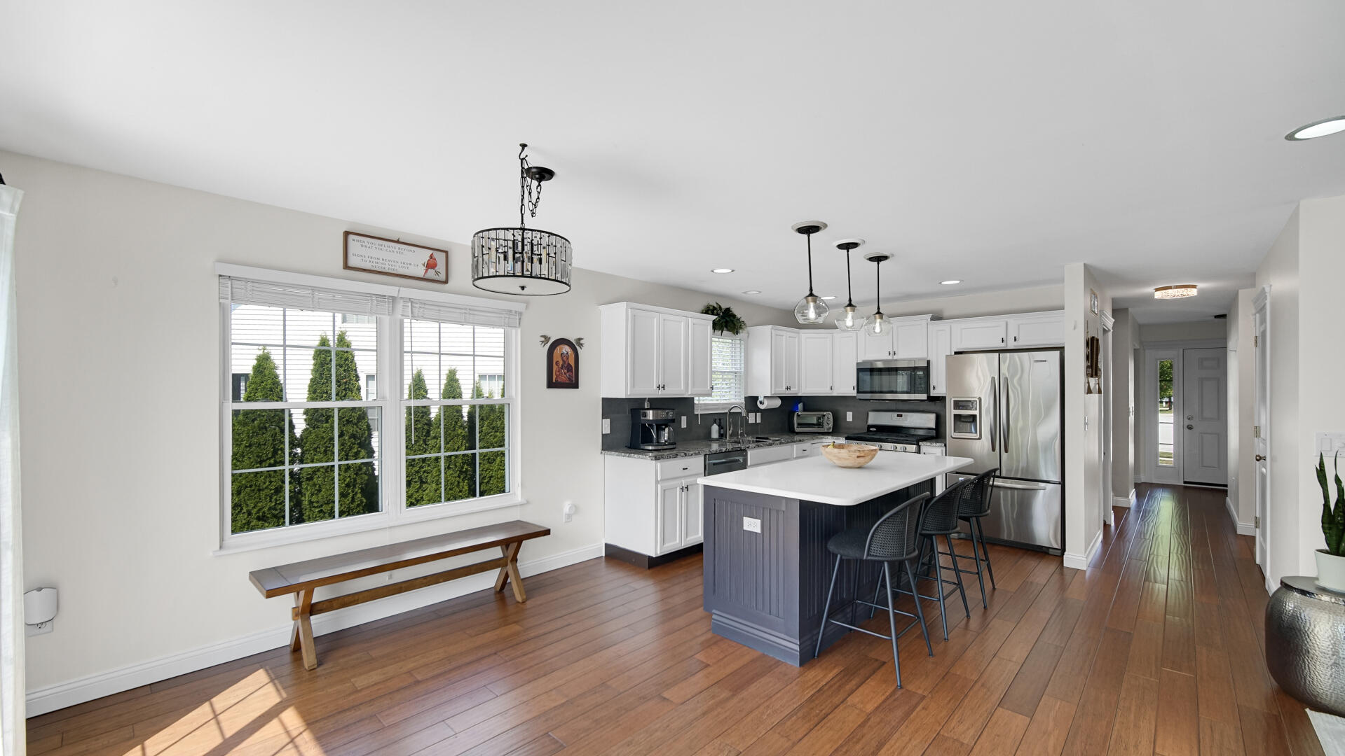 10300 Illinois Street Crown Point, IN 46307 - Photo 6 of 29 a open kitchen with stainless steel appliances granite countertop a stove dining table chairs and a large window with wooden floor