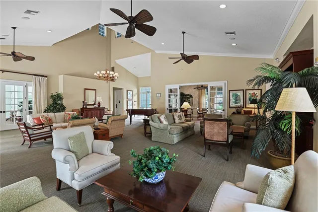 a living room with furniture kitchen view and a chandelier
