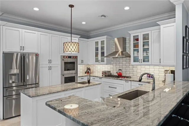 a kitchen with kitchen island granite countertop a sink a counter top space appliances and cabinets
