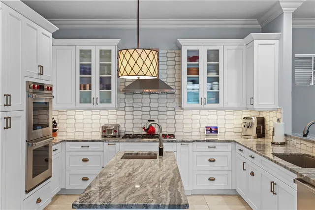 a kitchen with stainless steel appliances granite countertop a stove and white cabinets